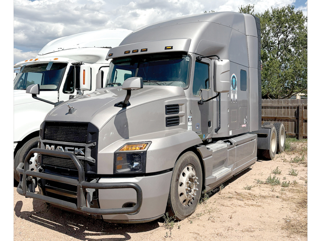 Mack Anthem semi-truck in a lot showing front and side view with protective bumper and grille guard.