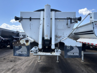 Dump trailer tail with Tri-king mud flaps and hydraulic chute showing ED26-34 model label? rear view of Ranco trailer with spill bars and hitch mechanism.