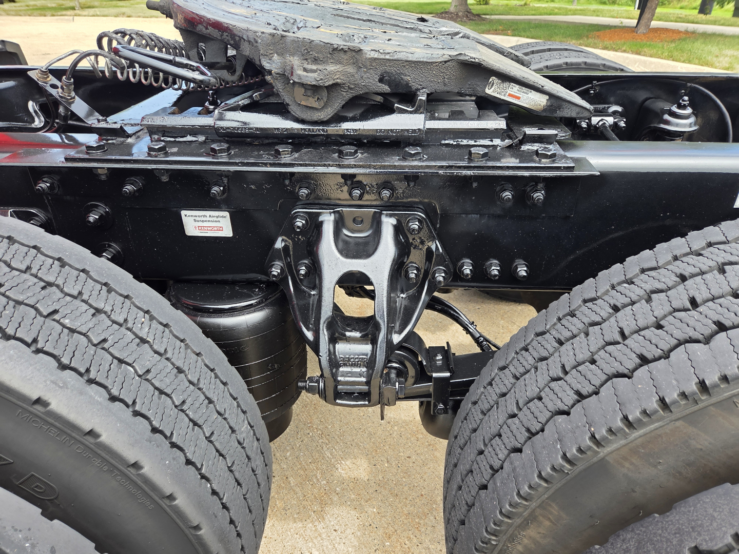 Truck chassis View showing fifth wheel hitch and dual rear wheels, Kenworth T680 undercarriage with suspension and drivetrain components.