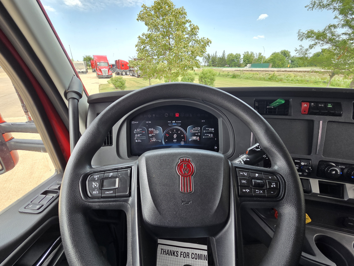 Kenworth T680 steering wheel and dashboard view showing steering wheel controls and instrument cluster.