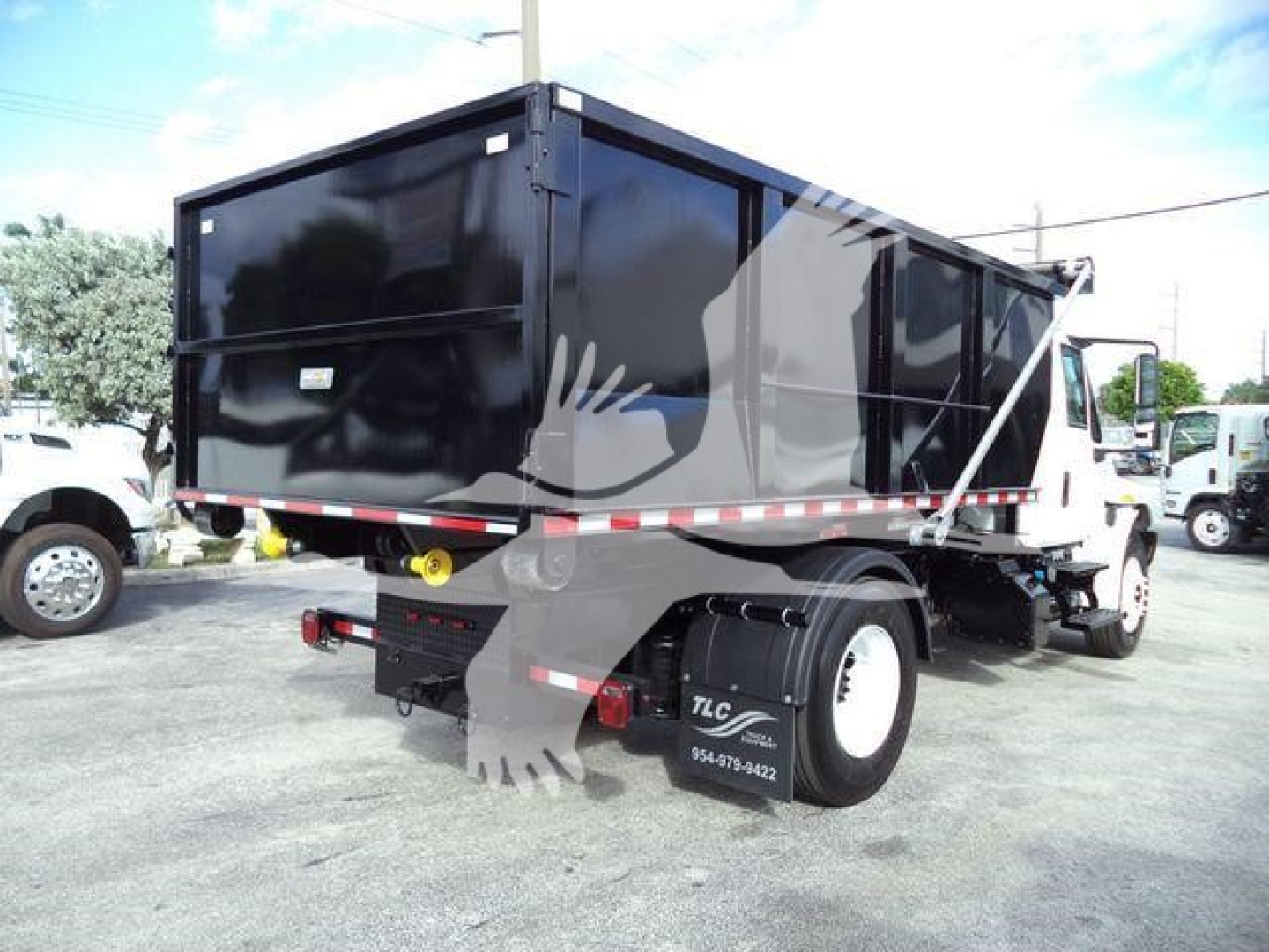 Dump truck bed of a 2019 International Durastar 4300 rolloff chassis showing black dump body and rear end with taillights and white cab.
