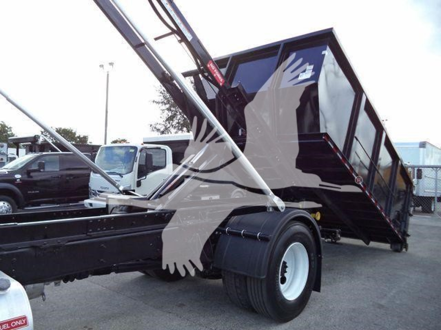 Truck chassis and tipped dump bed showing hydraulic hoist preparing to dump load on a 2019 International Durastar 4300 rolloff truck.