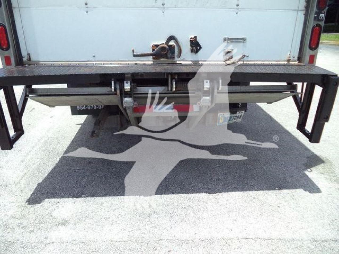 Isuzu NPR HD rear view showing steel bumper/step and hitch receiver, tailgate area, and platform with support brackets.