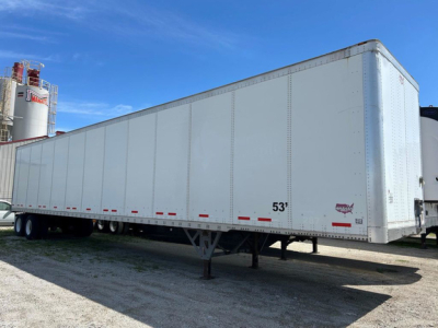 Trailer side view showing 53' Wabash dry van trailer with white exterior and landing gear, VIN label not visible.