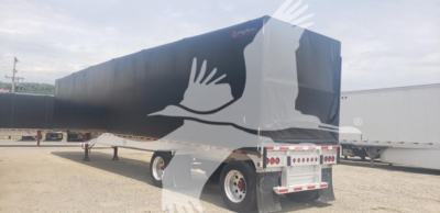 Mac Aluminum Flatbed trailer with curtain side showing 72K beam text and white bird artwork on black cover, rear view