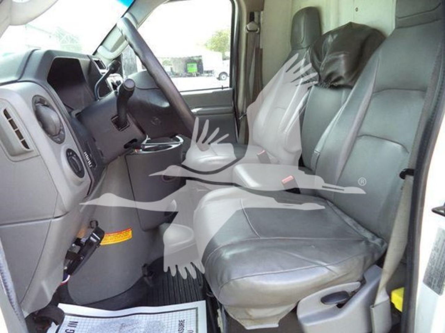 Ford E-Series cab interior showing driver and passenger seats with steering wheel, dashboard, and center console.