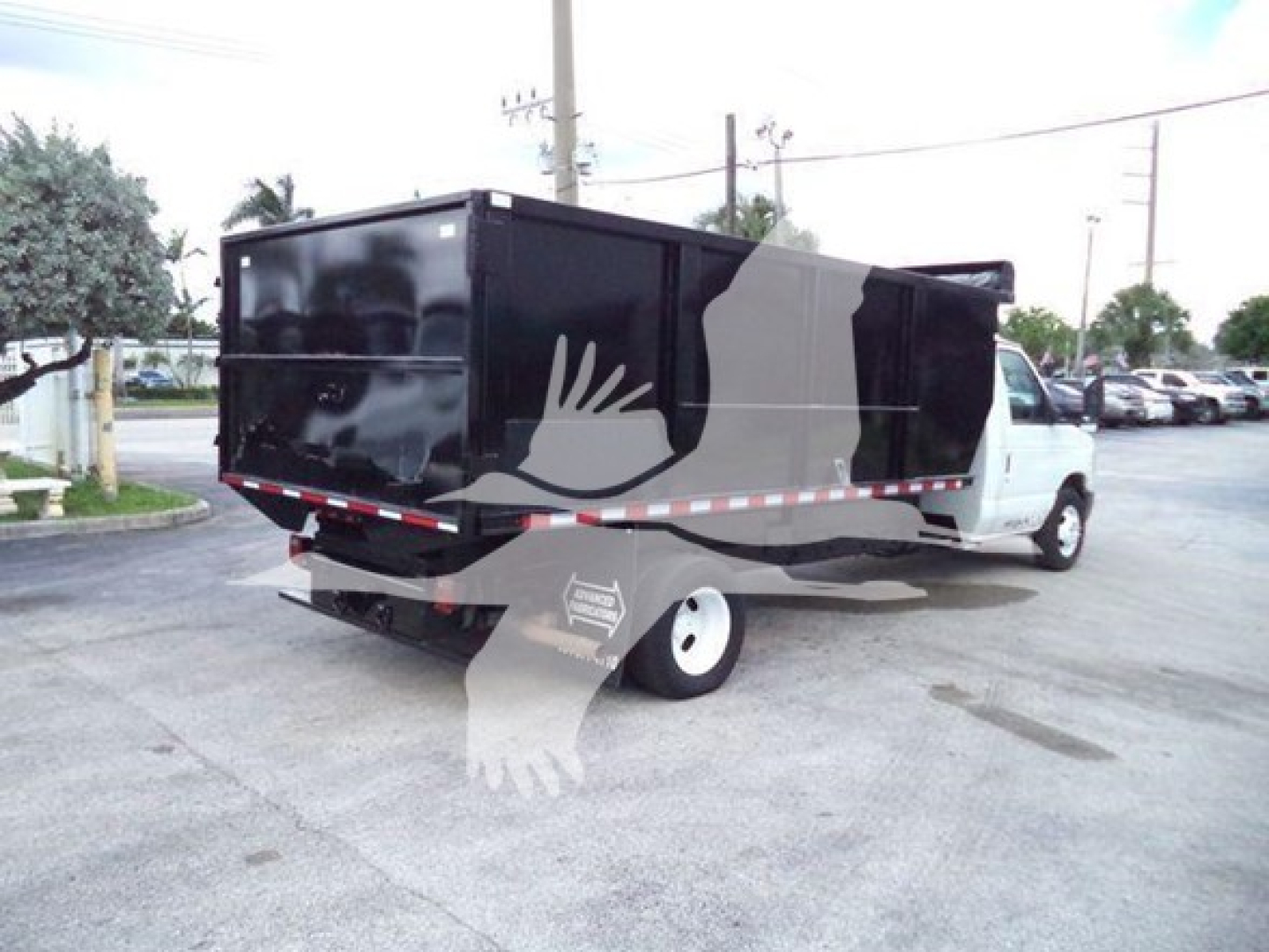 Dump truck body from the rear-left side showing a black dump bed attached to a white Ford E-450 chassis.