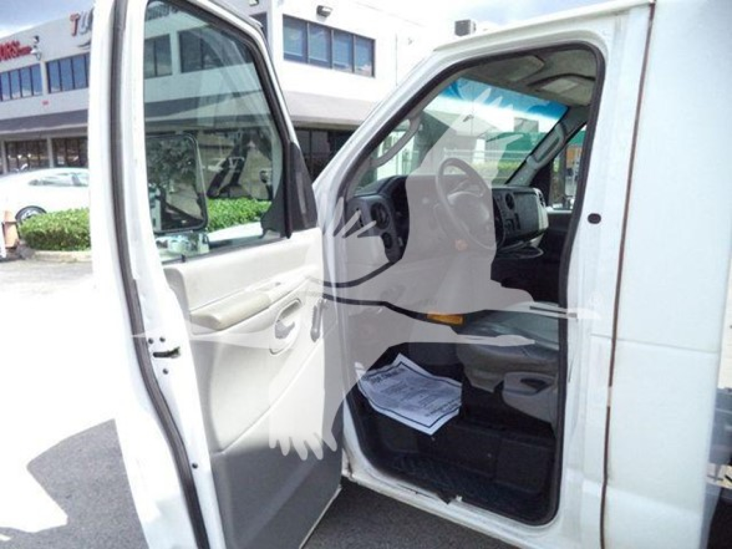 Ford E-Series van interior view with open driver and passenger doors showing dashboard and steering wheel.