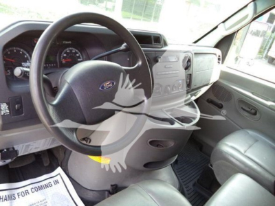 Ford E-series dash and steering wheel inside cab showing 2011 Ford E450 pickup truck interior. Center console with radio and vents visible.