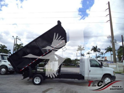 Ford E450 dump truck in-service showing a dumped dump bed raised on a white cab chassis with TLC Truck & Equipment watermark.