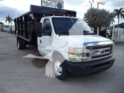 Dump truck with white cab and black dump bed, Ford E450, side view showing front grille and wheel wells.