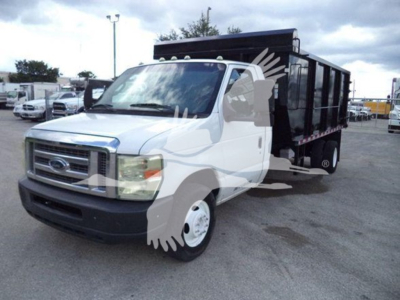 Ford E-Series dump truck with white cab and black dump bed, front grille and headlights visible.