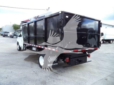Ford E-450 dump truck body in side and rear view showing black dump bed with rear doors and safety reflectors