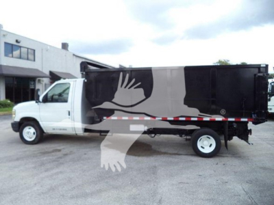 Ford E-450 dump truck side view showing large black dump bed with white cab and eagle watermark overlay