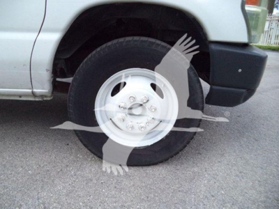 Truck wheel and front fender of a 2011 Ford E450 dump truck showing wheel and tire with hubcap.