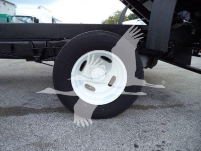 Ford E450 chassis showing wheel and undercarriage of dump truck body with white steel rim.