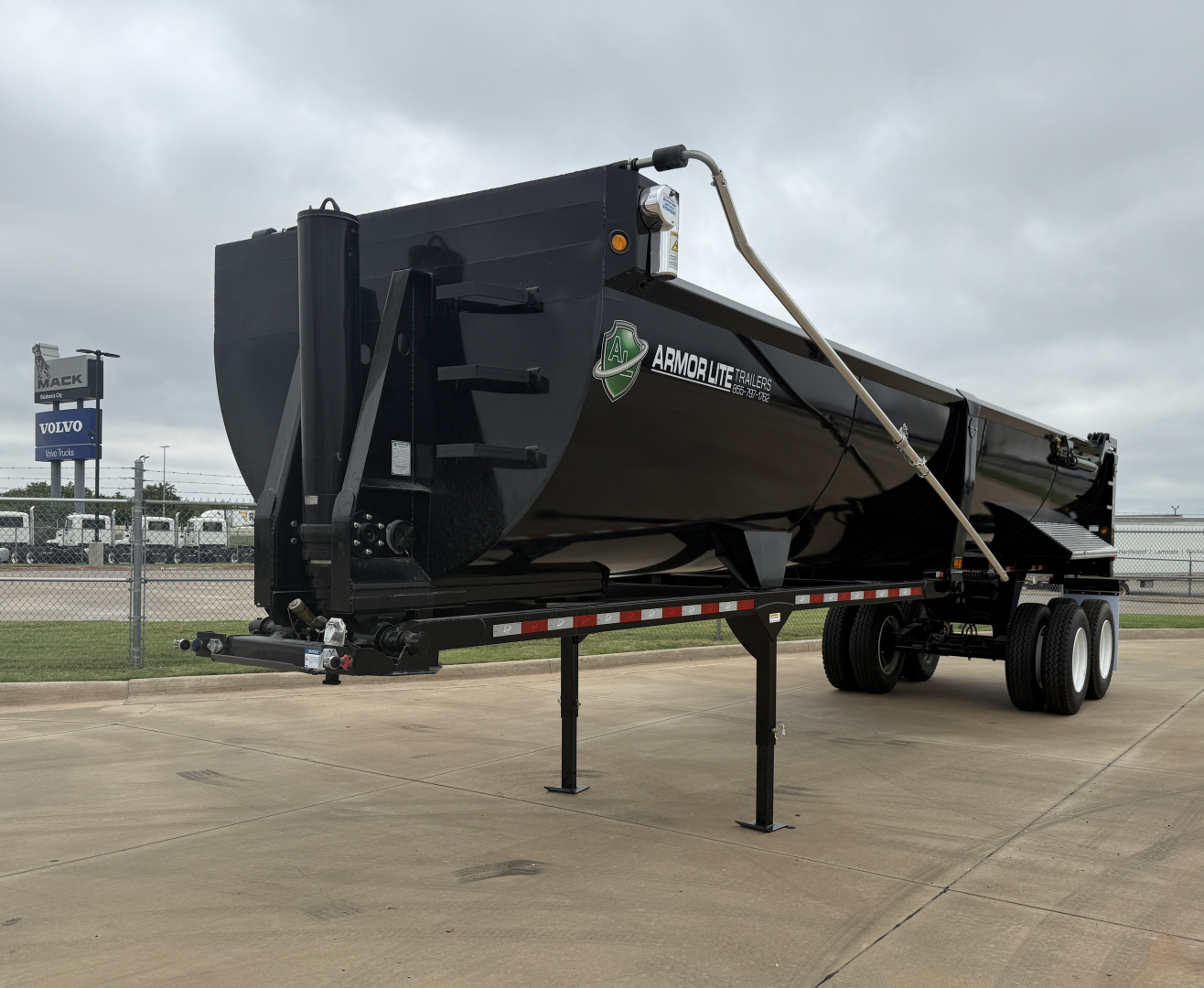 Armor Lite SHD32/48 dump trailer showing black steel dump body and dual axle with landing gear in foreground.
