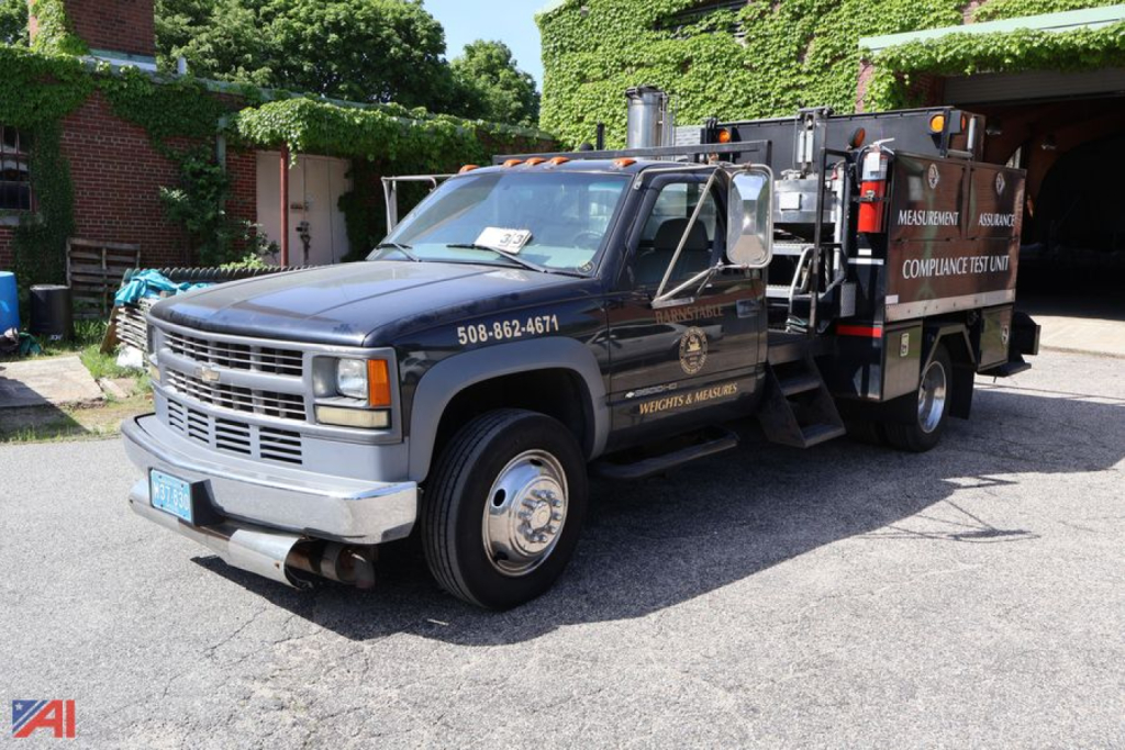 Chevrolet GMT-400 1-ton utility truck with service/utility body and equipment on it, side view showing front grille and ladder rack