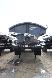 Jet Tri Axle Super Spread Side Dump trailer showing hydraulic hitch and spread axle mechanism, Jet logo visible on the dump body.