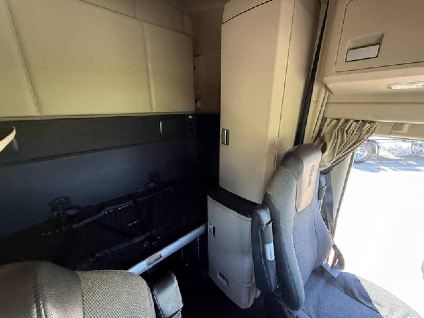 Kenworth T680 truck cab interior showing driver's seat and storage cabinet