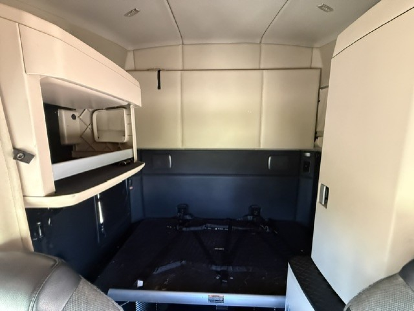 Kenworth T680 sleeper cab interior cargo area with bunk space and overhead storage shelves.