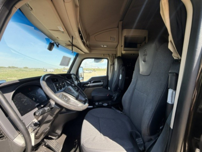 Kenworth T680 truck cab interior showing driver seat and dashboard with steering wheel and overhead compartment