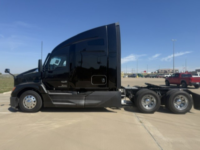 Kenworth T680 cab with sleeper, side view showing black glossy exterior, dual rear axles, fuel tanks, and chrome wheels.