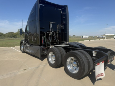 Kenworth T680 cab with rear wheels visible, hydraulic lines and wiring at back of cab, black glossy finish, chrome wheels.