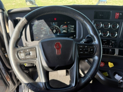 Kenworth T680 steering wheel and dashboard view showing digital gauges and control cluster.
