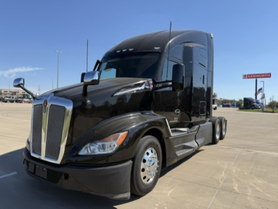 Kenworth T680 tractor-trailer in black showing aerodynamic cab, front grille, and side mirrors.