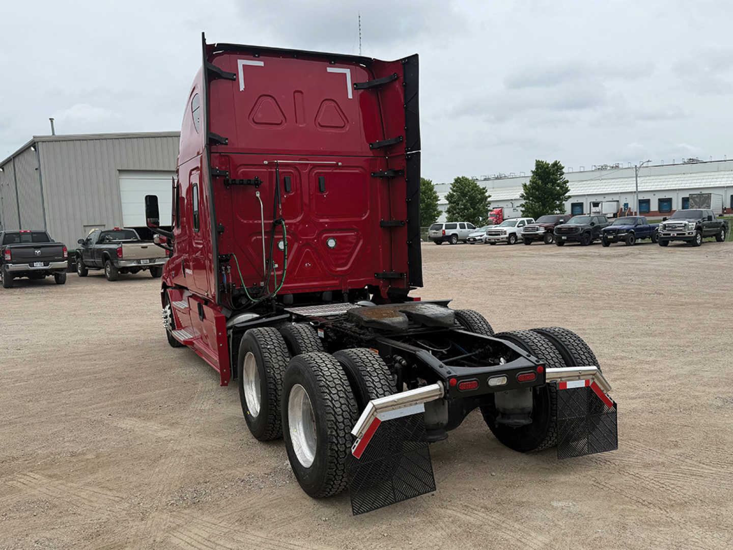 Freightliner Cascadia126 tractor rear view showing tandem axles and mud flaps.