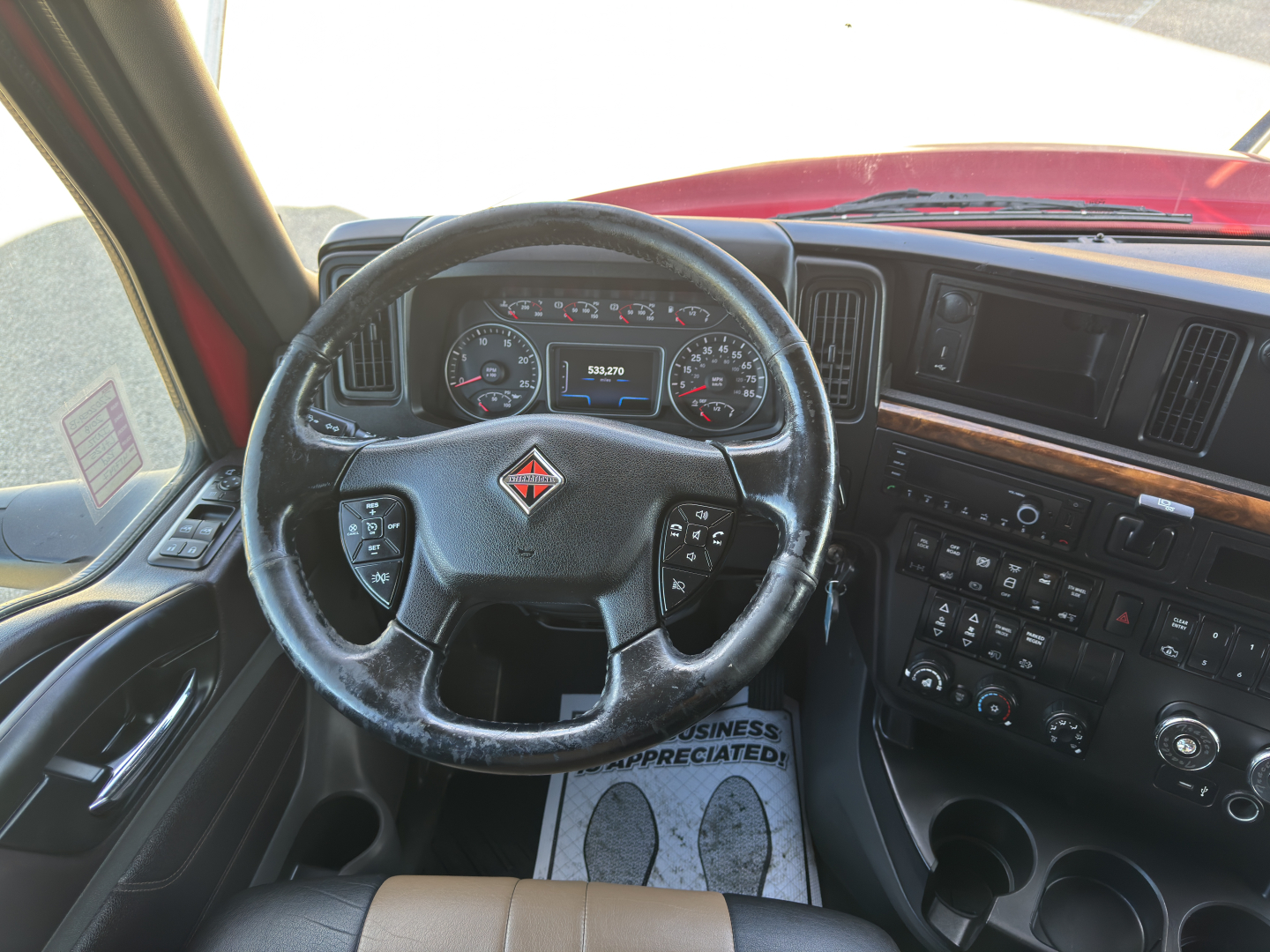 Interior view of 2018 International LT625 dashboard and steering wheel with center console controls.