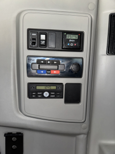 Dashboard controls panel inside a 2018 International LT625 sleeper cab showing switches, climate controls, and radio. Visible text includes disabled/ON buttons and display units.