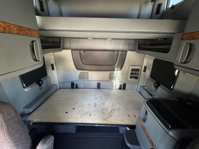 Interior sleeper cab cargo area showing flat plywood platform and storage compartments in a 2018 International LT625 truck cab.