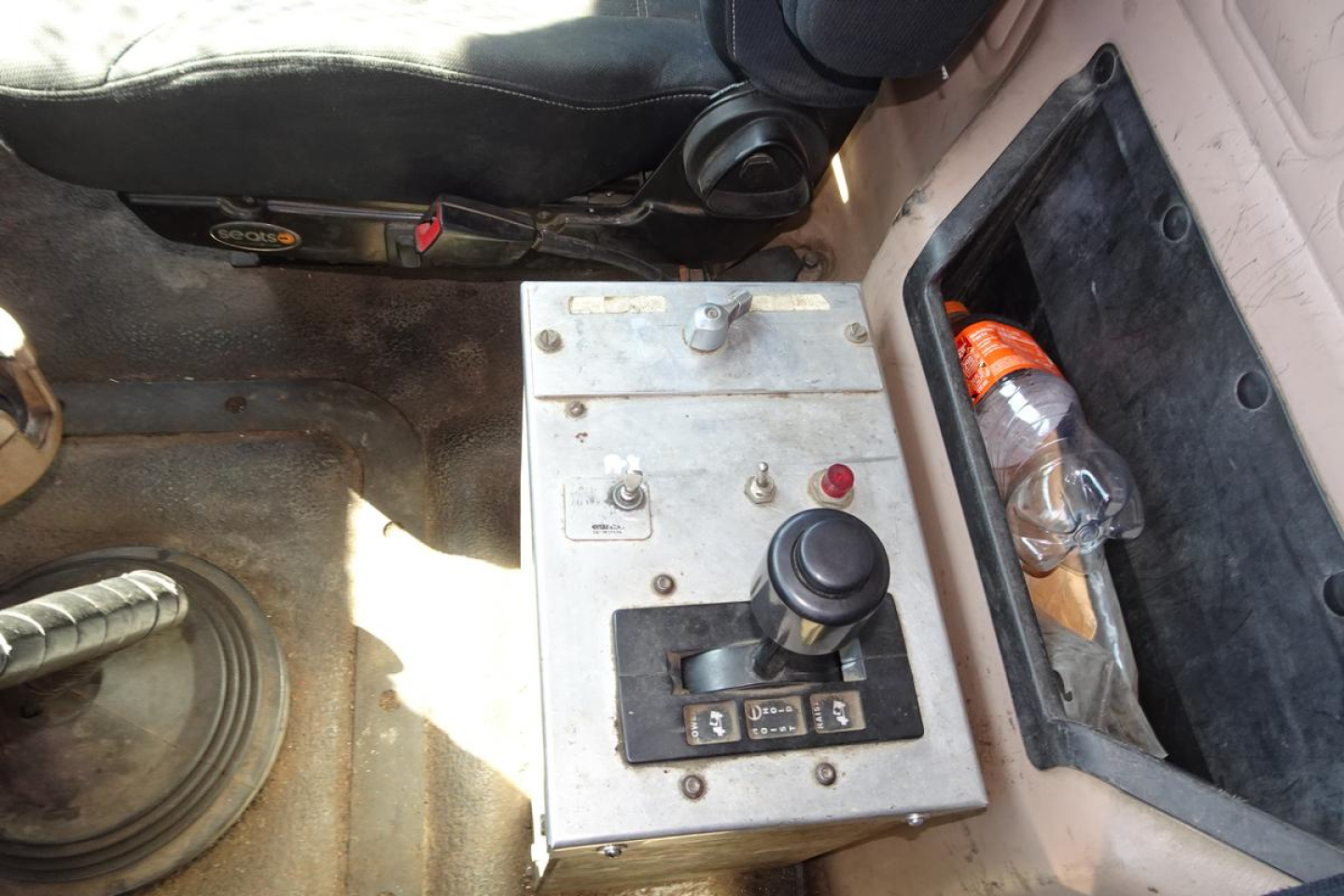 Mack CV Granite CV713 cab interior showing gear control panel with joystick and switches, seat, and storage pocket.