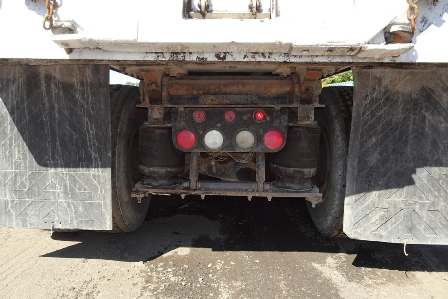 Back view of a Mack CV Granite (CV713) dump truck chassis showing rear coupler, hydraulic lines, and red/gray valves.