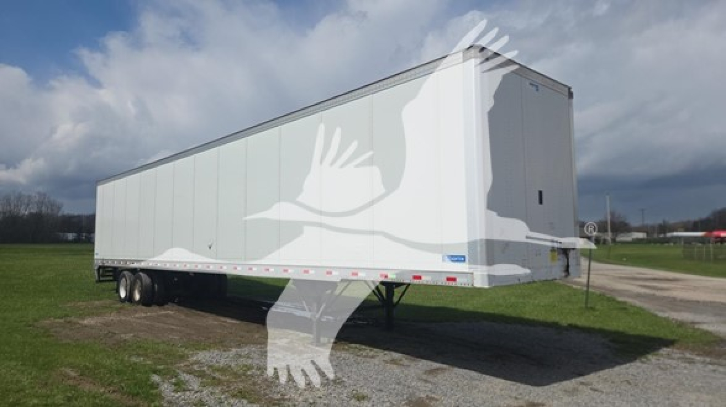 Trailer side view of a 2019 Stoughton plate van with dual rear axles, white exterior, parked on grass.