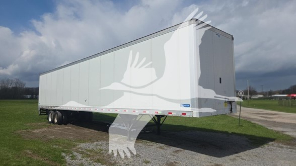 Trailer side view of a 2019 Stoughton plate van with dual rear axles, white exterior, parked on grass.