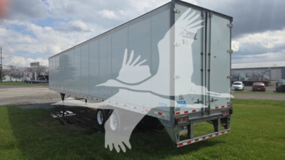 Trailer side and rear view of a 2019 Stoughton plate van with a light gray exterior, two rear doors, and gable overhang, displaying stock and VIN labels.