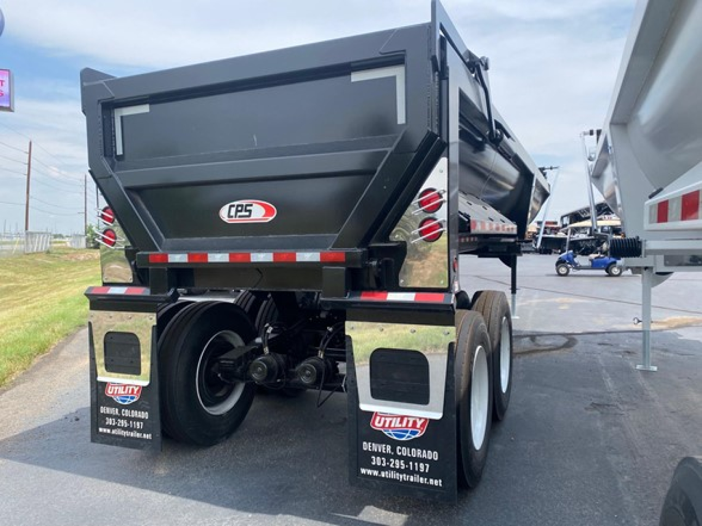 Frameless steel rock end dump trailer rear view showing CPS logo, dual rear dumpsters, mudflaps, and wheel/axle assembly.