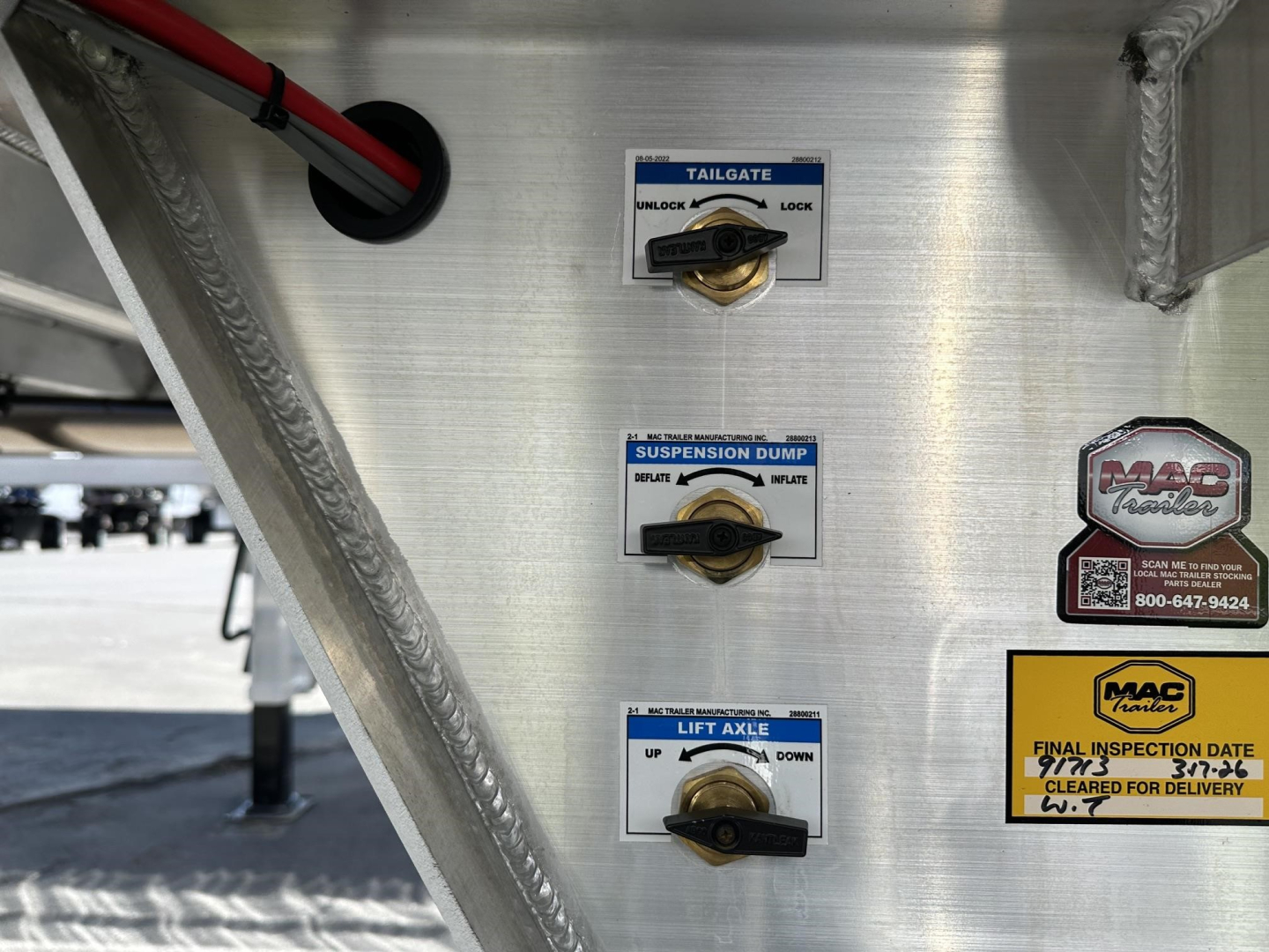 Mac lightweight frameless aluminium end dump trailer features tailgate, suspension dump, and lift axle controls with stickers visible on the aluminum body.