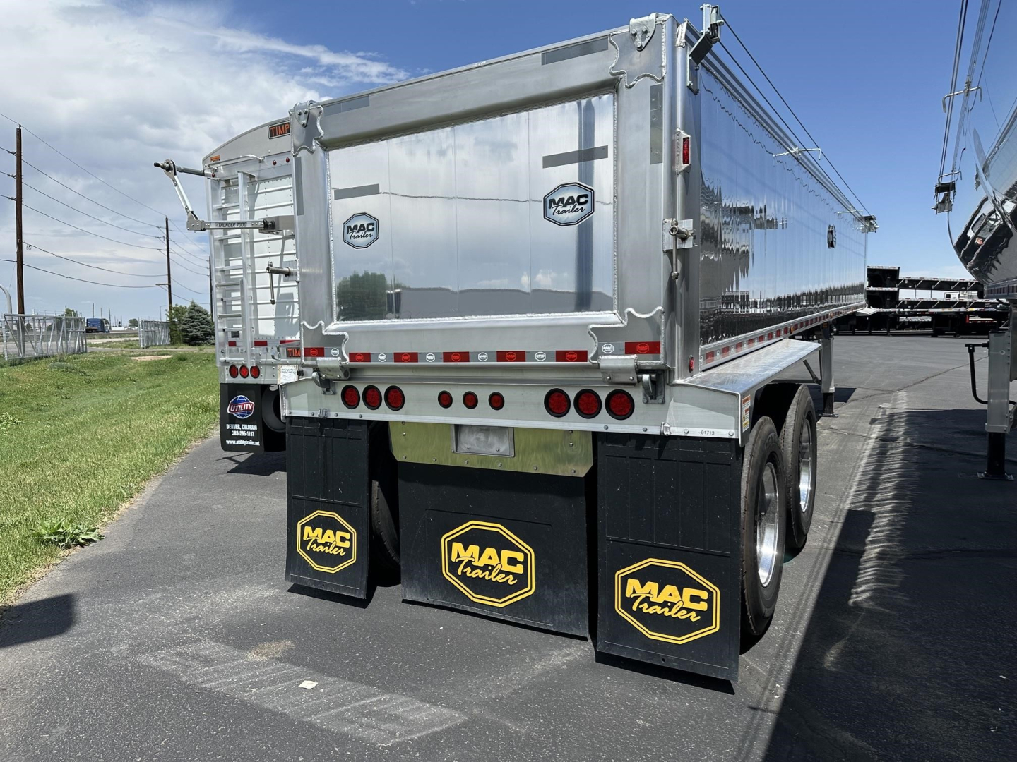Mac trailer aluminum end dump with frameless design showing rear view and mudflaps with Mac Trailer logos