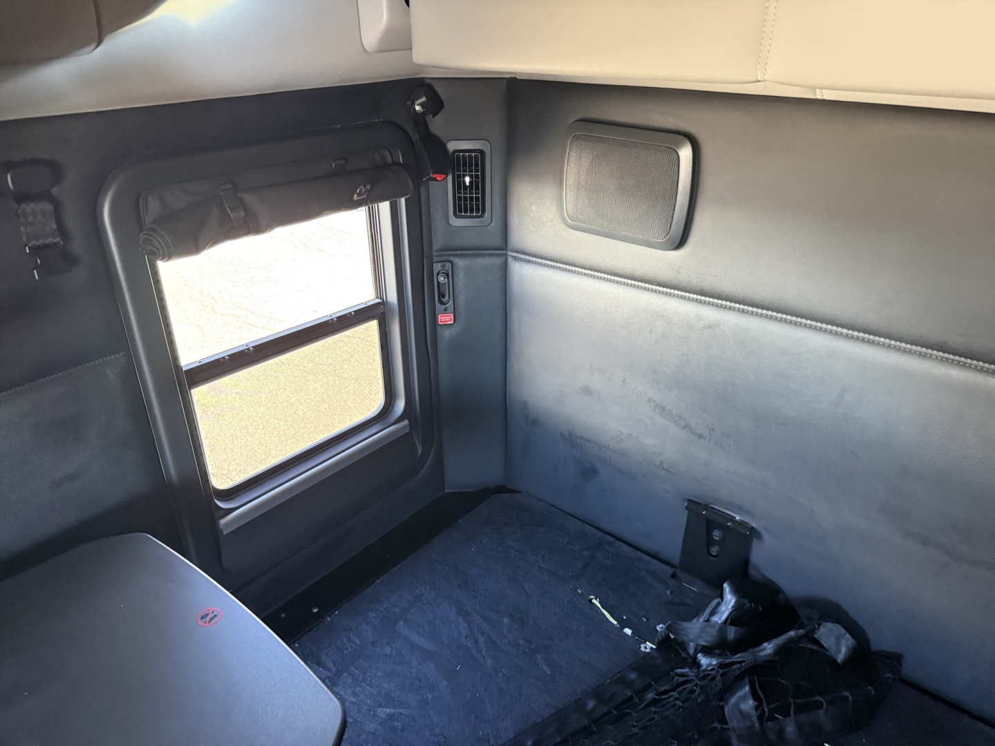 Kenworth T680 truck cab interior showing window, door, and side panel with a small vent and control module visible.