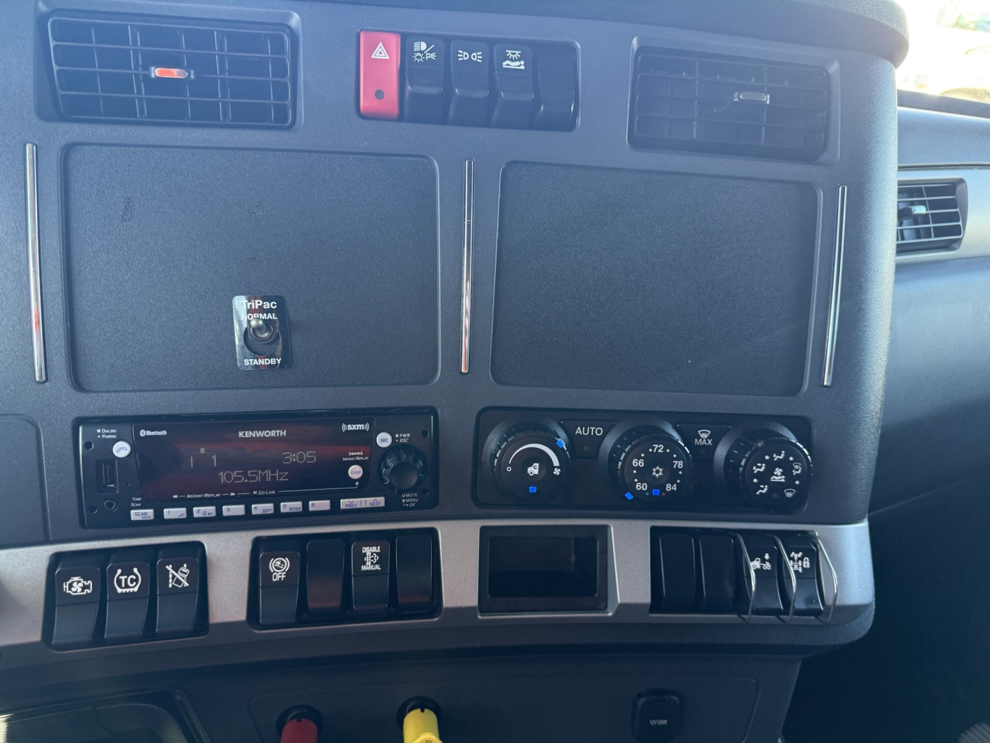 Kenworth T680 dashboard center console showing radio, climate controls, and switches in view.