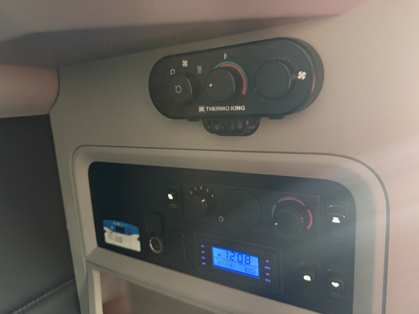 Kenworth T680 interior dash area showing climate controls and radio display with blue backlit screen.