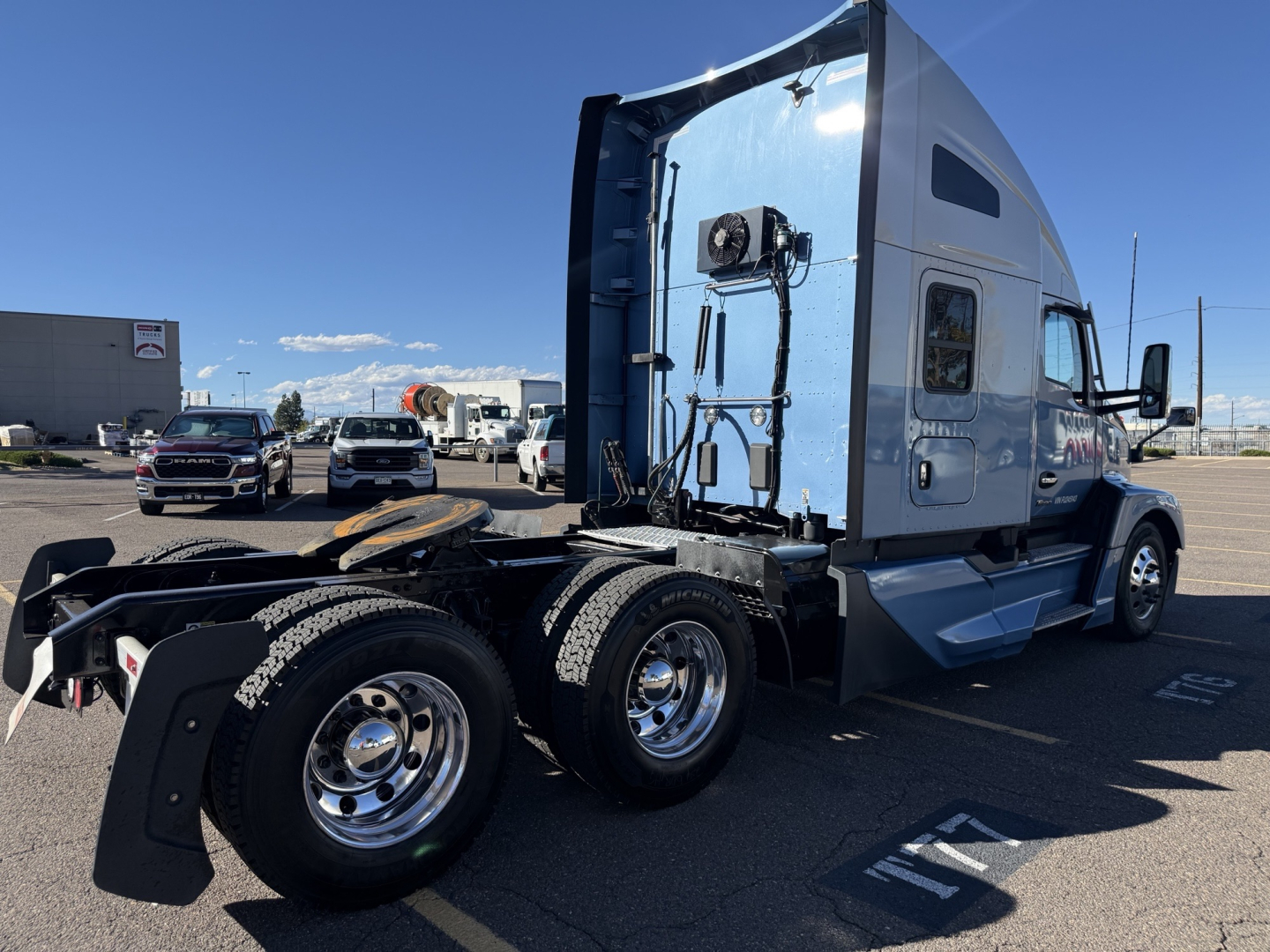 Kenworth T680 conventional sleeper truck side view showing rear dual axles and fuel tank area.