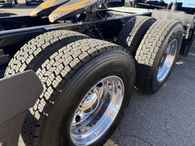 Kenworth T680 truck rear wheels and dual tires on trailer chassis, chrome rims, tread patterns visible.