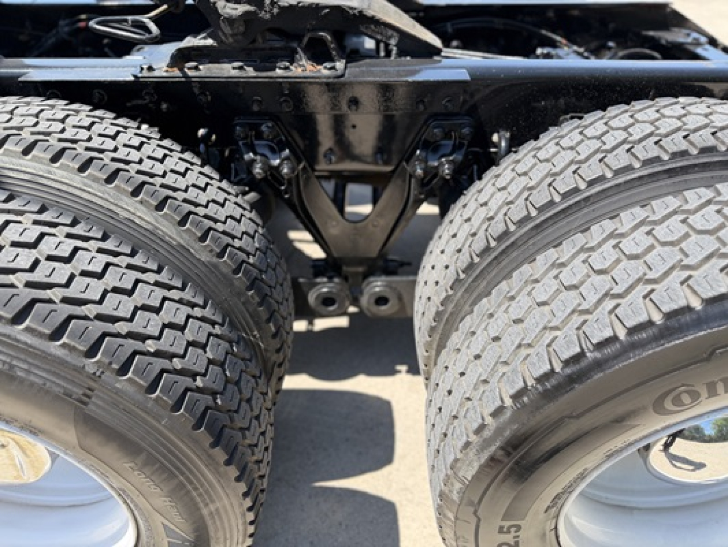 Kenworth T680 rear dual rear tires and chassis framing as seen from below showing suspension and axle assembly.