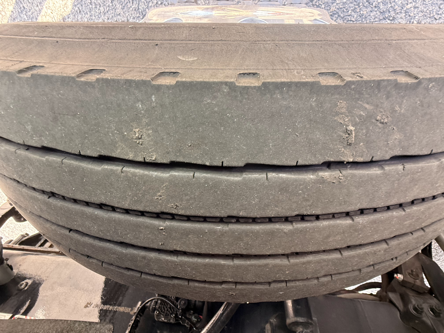 Tire stack on a Mack Granite truck showing worn tread and flatbed-related components.