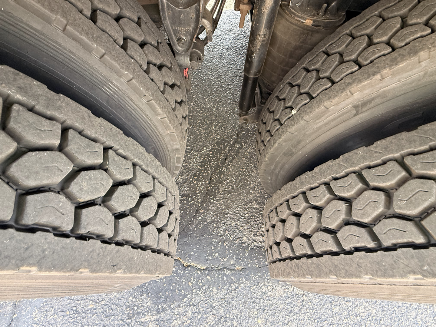 Mack Granite truck rear dual tires view showing tread pattern and gap between wheels with chassis components visible.
